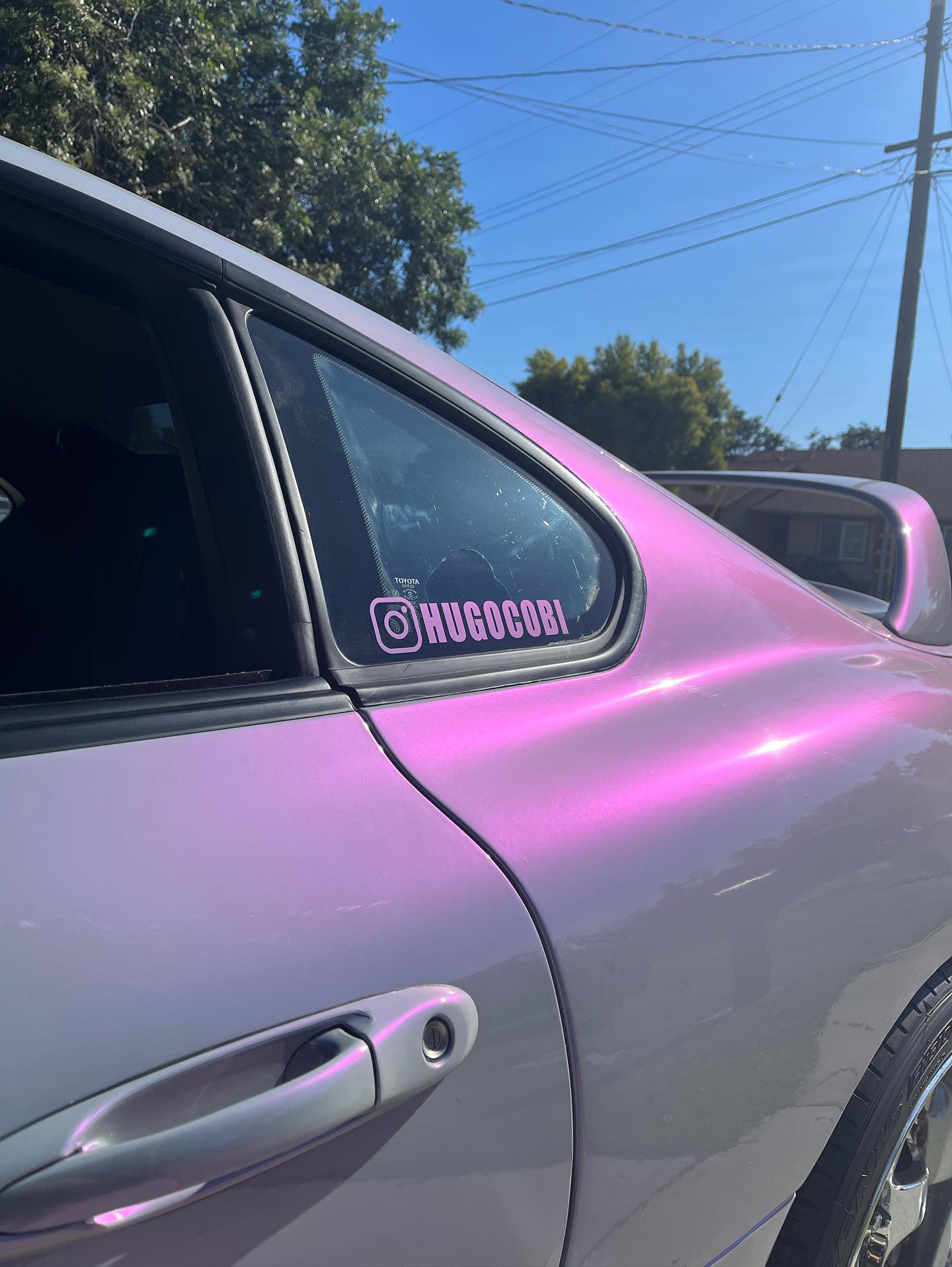 Custom social media decals on a car window, showcasing a personalized Instagram handle sticker.